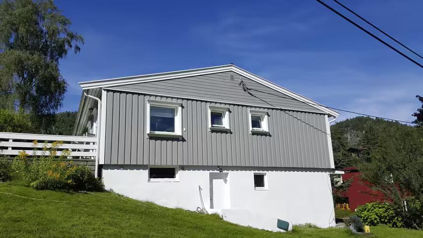 Hus med nytt panel, slettet grunnmur, nytt blikkarbeid og nymalt fasade